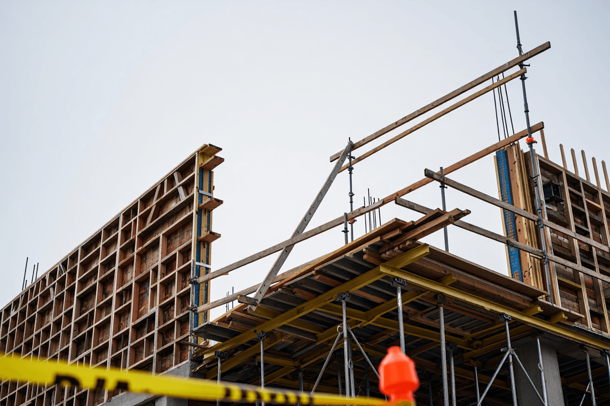 A foreman reviewing safety plans on a clipboard at a construction site